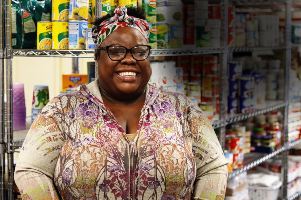 Sharron, a shopper at Raider Necessities, poses for a photo in the pantry.