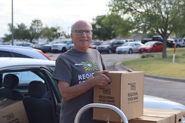 Regional Food Bank Volunteer Steve Kage loads home delivery boxes into his vehicle.