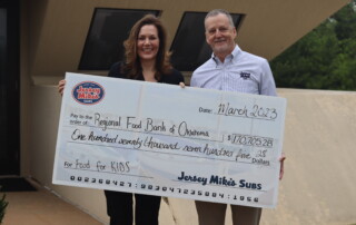 Stacy Dykstra, Regional Food Bank CEO, and Charlie Brown, franchise owner and area director for Jersey Mike’s, pose for a photo after announcing the final tally of the Jersey Mike’s Month of Giving.