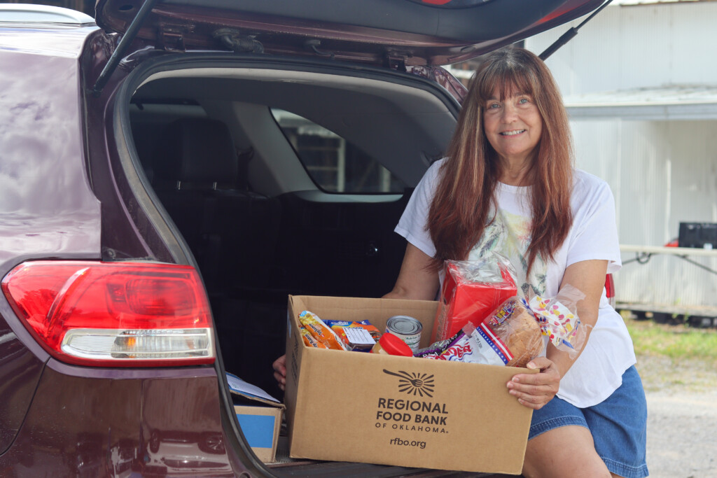 Senior Neighbor Senior neighbor holding a Regional Food Bank box of food.
